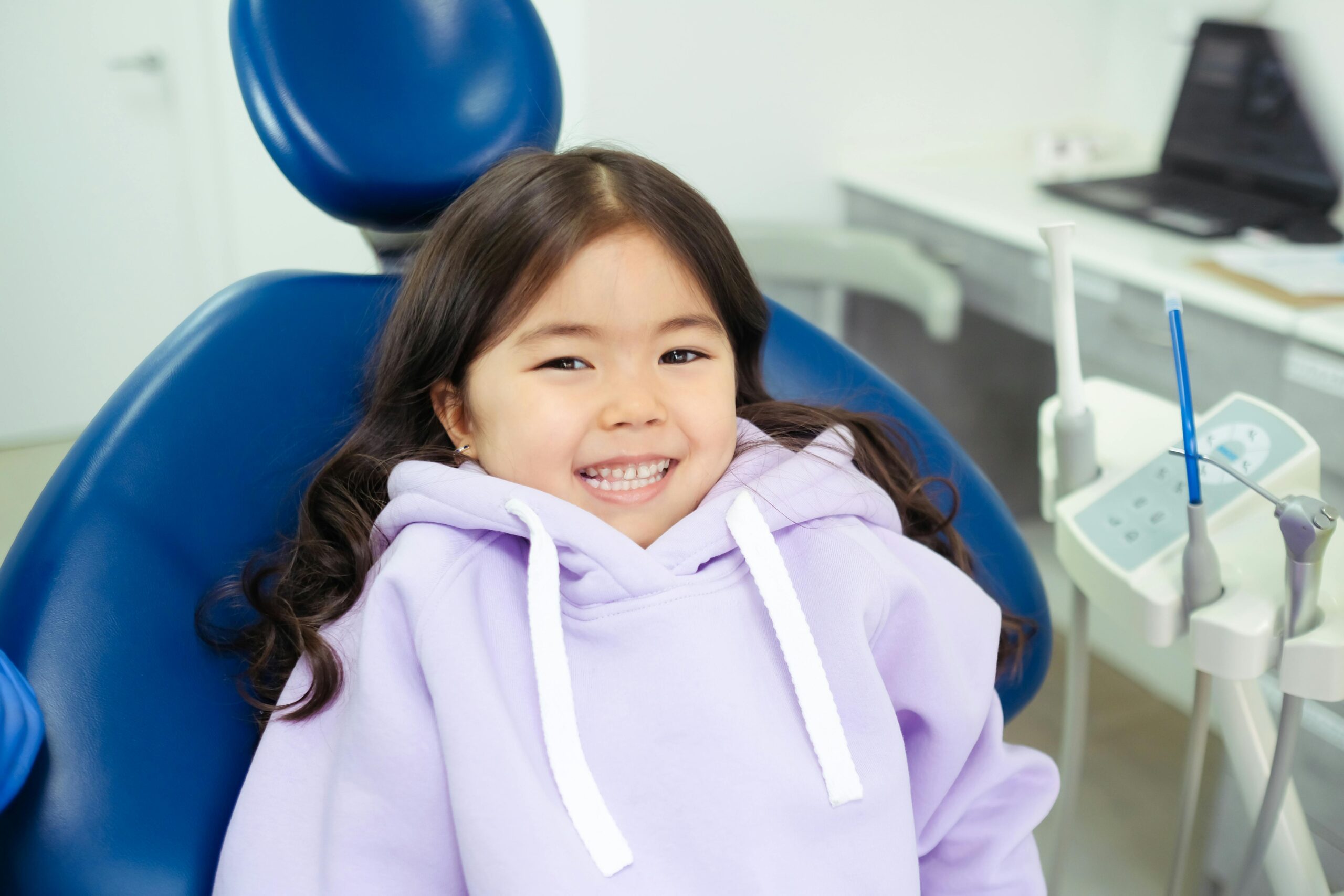 Girl in Purple Hoodie Sitting on Blue Chair